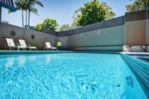 a swimming pool with blue water in a house at Quality Hotel City Centre in Coffs Harbour