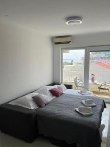 ein Schlafzimmer mit einem Bett und einem großen Fenster in der Unterkunft Bellissima by the Sea in Makarska