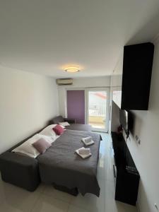 ein Schlafzimmer mit einem großen Bett mit rosa Kissen in der Unterkunft Bellissima by the Sea in Makarska