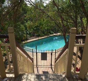 una piscina detrás de una valla de madera en Tranquil Garden Hideaway, en Ormeau