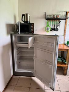 an open refrigerator in a kitchen with a microwave at Cabañas Tangaroa y Hamea in Hanga Roa