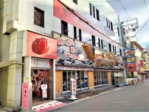 a building with signs on the side of a street at Cafe&Hostel Kimi to Ichigo in Osaka