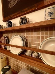 a shelf with plates and cups on it at Biennale Apartment Venice in Venice