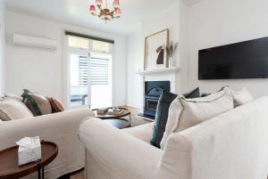 - un salon avec un canapé blanc et une cheminée dans l'établissement Central Elegance: Cottage Gem with Parking, à Launceston