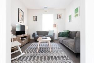 uma sala de estar com um sofá e uma mesa em What a Charmer: Near the CBD Parking & Wifi em Launceston