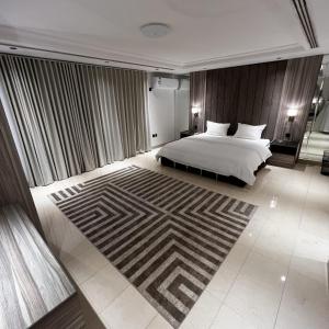 een slaapkamer met een bed en een groot tapijt bij فلل لافيندا الفندقية in Riyad