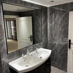 een badkamer met een witte wastafel en een spiegel bij فلل لافيندا الفندقية in Riyad