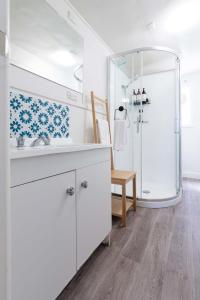 uma casa de banho branca com um lavatório e um chuveiro em What a Charmer: Near the CBD Parking & Wifi em Launceston