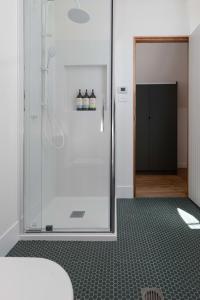ein Bad mit einer Dusche und einer Glastür in der Unterkunft City Lights & Tiny Delights: Near CBD & Parking in Kings Park