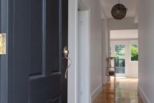 a blue door in a room with a hallway at Cute & Comfortable Cottage: Near City with Parking in Kings Park