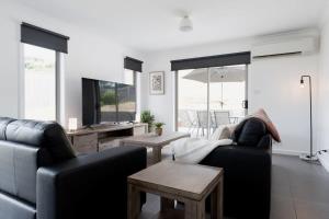 sala de estar con sofá y mesa en Modern Delight: Cosy Home with Parking, en Invermay