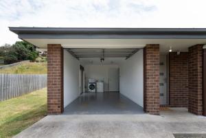 an empty garage with a brick wall at Modern Delight: Cosy Home with Parking in Invermay