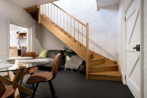 a staircase in a living room with a table and chairs at Little City Cottage with Free Onsite Parking in Launceston