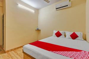 um quarto com uma cama grande e almofadas vermelhas em Super OYO Flagship 81472 The Harsa Inn em Sānkchi