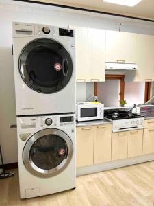 een keuken met een wasmachine en een magnetron bij #Newopen #3rooms '2 beds rooms and 1 dining room' #2 line 4 minutes walk from station #airport bus stop in front of home in Seoul