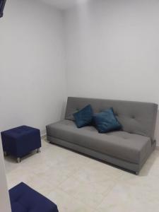 - un canapé avec deux oreillers bleus dans le salon dans l'établissement Hermosos apartamentos en caribe campestre, coveñas, à Coveñas