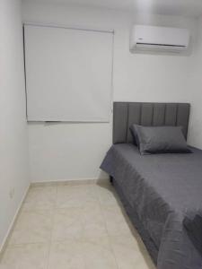 1 dormitorio con cama y pantalla grande en Hermosos apartamentos en caribe campestre, coveñas en Coveñas