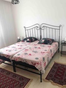 een slaapkamer met een bed met een roze deken en kussens bij Charmant appartement à la Soukra in La Soukra