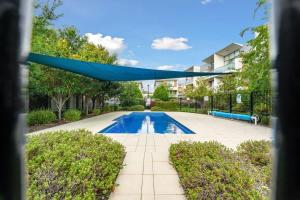 a swimming pool with a blue canopy over it at Tranquil 1-Bed Apartment with Courtyard, Pool, BBQ in Phillip