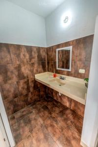 La salle de bains est pourvue d'un lavabo et d'un miroir. dans l'établissement Casa Blanca, à Puerto San José