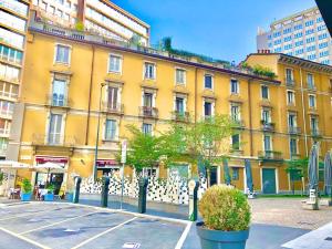 a yellow building with a white fence in front of it at GOLD HOUSE appartamento stazione centrale in Milan