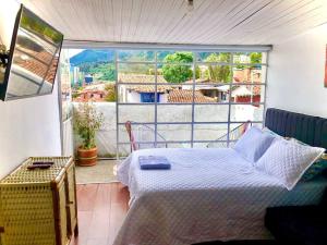 a bedroom with a bed and a large window at Casa en La Candelaria con increible vista y balcón in Bogotá