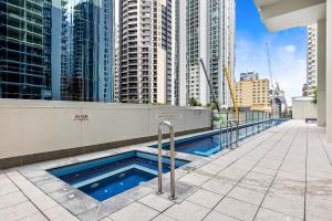 una piscina en la azotea de un edificio con edificios altos en 1-Bed Brisbane City Centre with Pool, BBQ & Gym, en Brisbane