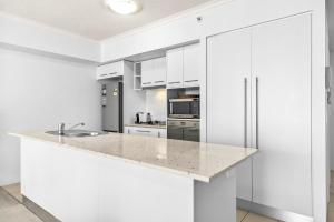 Una cocina con gabinetes blancos y encimera. en 1-Bed Brisbane City Centre with Pool, BBQ & Gym, en Brisbane