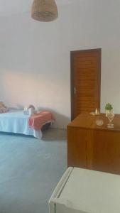 um quarto com uma cama e um armário de madeira em Pousada Vila Rosa - Caraiva em Caraíva