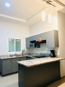 uma cozinha com armários cinzentos e uma bancada em Casa moderna en catacamas em Catacamas