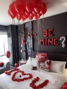a bed with red hearts and balloons on it at Hostal Paris in Lima