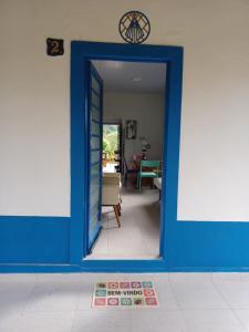 a blue door into a living room with a table at Chale Jatoba Monteiro Lobato in Monteiro Lobato