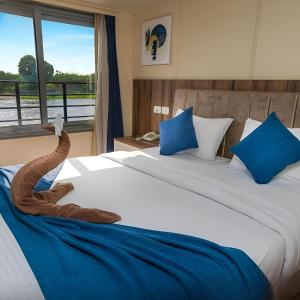 Un dormitorio con una cama grande con almohadas azules y una ventana en NILE CRUISE NB Every Saturday from Luxor 4 nights, and every Wednesday from Luxor 3 nights, en Luxor