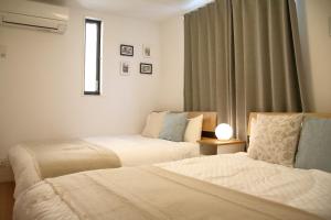 um quarto de hotel com duas camas e uma janela em Casa Stella 2 Capricorn by Liaison em Osaka