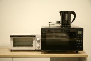 a coffee maker sitting on top of a microwave at Casa Stella 1 Aquarius by Liaison in Osaka