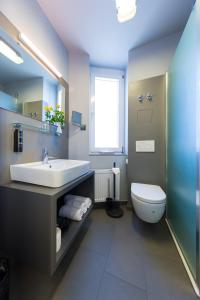ein Bad mit einem Waschbecken, einem WC und einem Fenster in der Unterkunft mk hotel remscheid in Remscheid