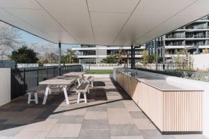 a patio with tables and chairs on a building at Pristine 2-Bed Apartment with Pool and BBQ in Phillip