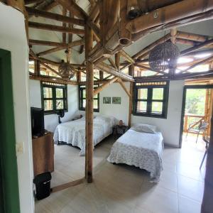 een slaapkamer met 2 bedden in een kamer met houten plafonds bij Carayurú in Mitú