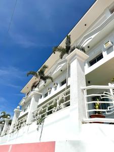 a large white building with palm trees on the balconies at Oceana Bay Coron in Coron