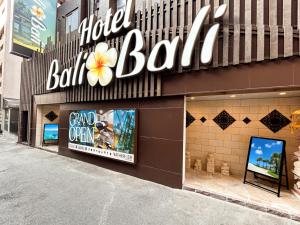 una tienda frente a un edificio con un cartel de globo de hotel en Hotel BaliBali 鶯谷, en Tokio