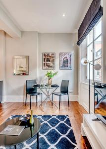 sala de estar con mesa y sillas en Arcore Premium Apartments: Mayfair, en Londres