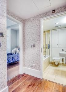 a bathroom with a shower and a toilet and a bed at Arcore Premium Apartments: Mayfair in London