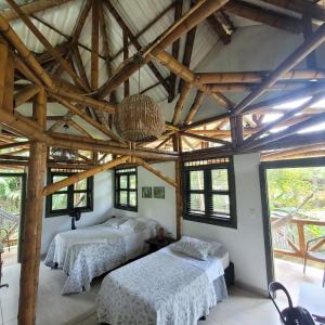 2 łóżka w pokoju z drewnianymi sufitami i oknami w obiekcie Carayurú w mieście Mitú