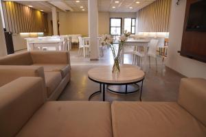 Zimmer mit Sofas und einem Tisch mit einer Blumenvase in der Unterkunft Hotel Alpre in Villa Carlos Paz