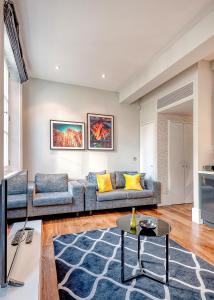 Arcore Premium Apartments: Mayfair في لندن: غرفة معيشة مع أريكة وطاولة