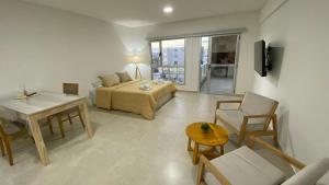a hotel room with a bed and a table and chairs at Orillas II in Puerto Madryn
