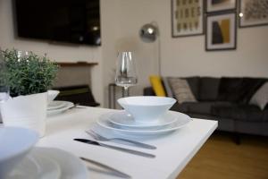 a table with plates and bowls and a wine glass at Deluxe 2 bedroom home in London in London