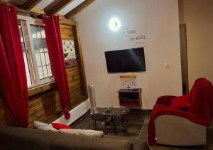 a living room with a couch and a flat screen tv at Villa Cachiman in Pointe-Noire