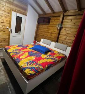 a bed with a colorful comforter in a room at Villa Cachiman in Pointe-Noire