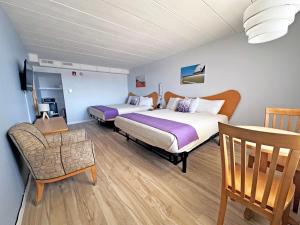 a hotel room with two beds and a chair at Shalimar Resort in Wildwood Crest